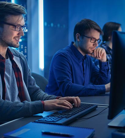 Team of Young IT Programers Working on Desktop Computers in Data Center System Control Room. Displays Show Concept: Software Development / Code Writing / Database Architecture. Technical Department