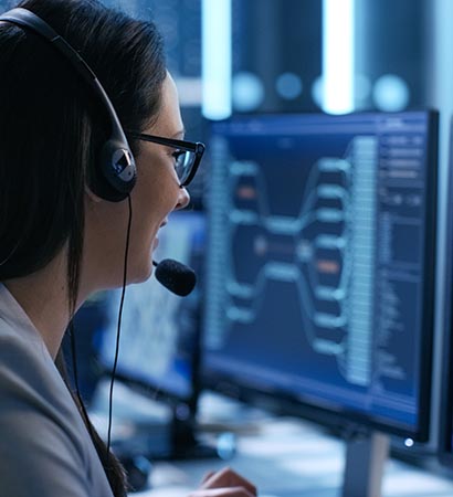 In the System Control Center Woman working in a Technical Support Team Gives Instructions with the Help of the Headsets. Possible Air Traffic/ Power Plant/ Security Room Theme.